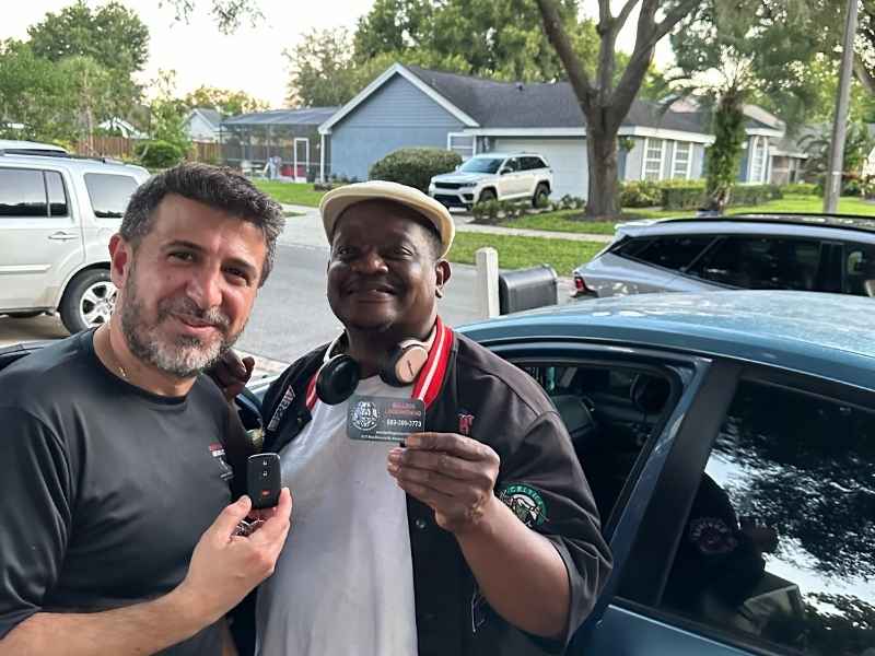 A happy customer receiving a new car key from a professional automotive locksmith in Sanford, showcasing fast and reliable car key replacement services.