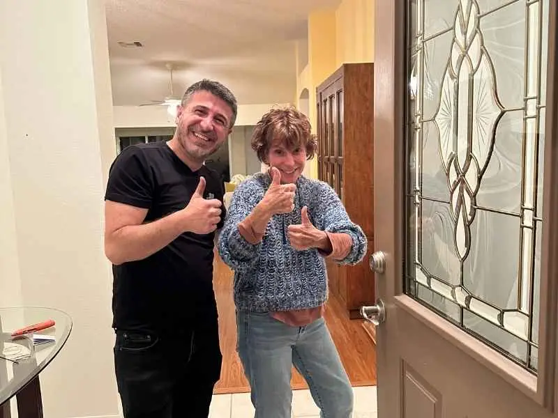 A happy customer giving a thumbs-up with a residential locksmith in Sanford after successfully securing her home with a lock change or repair service.